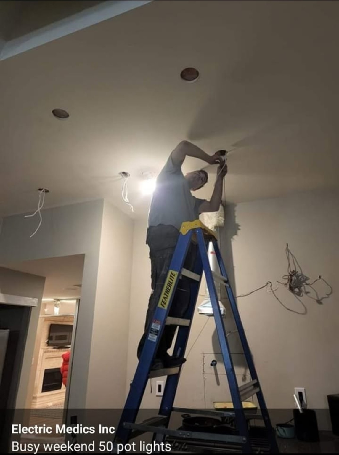 Electrician installing pot lights in a home